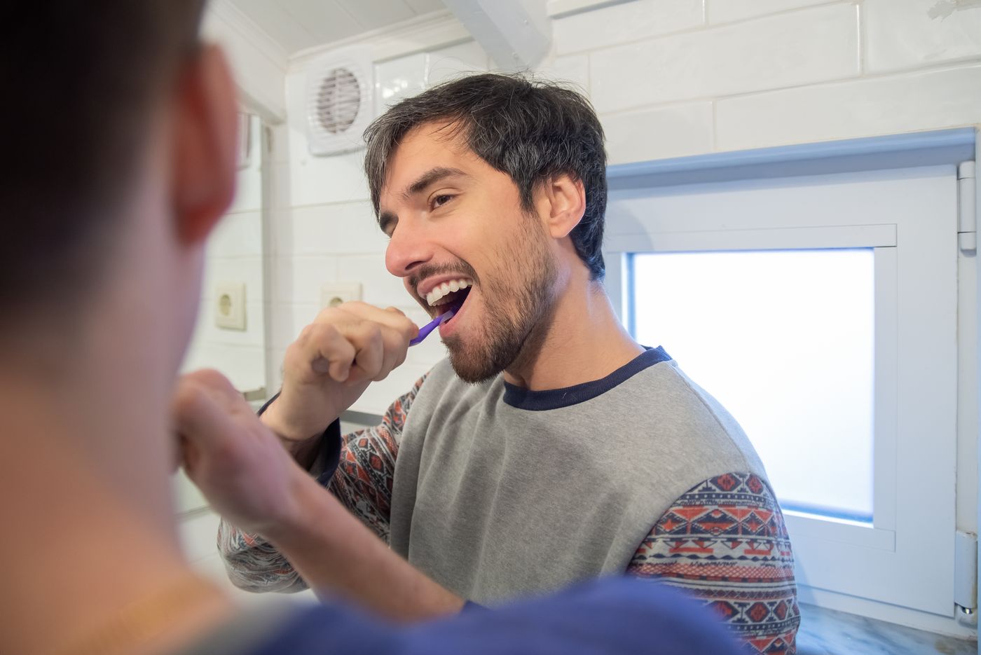 Two people brushing their teeth together as part of a morning routine