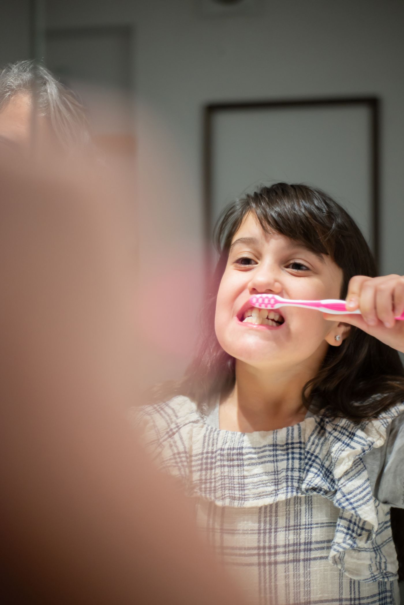 A child brushing her teeth as part of a daily routine