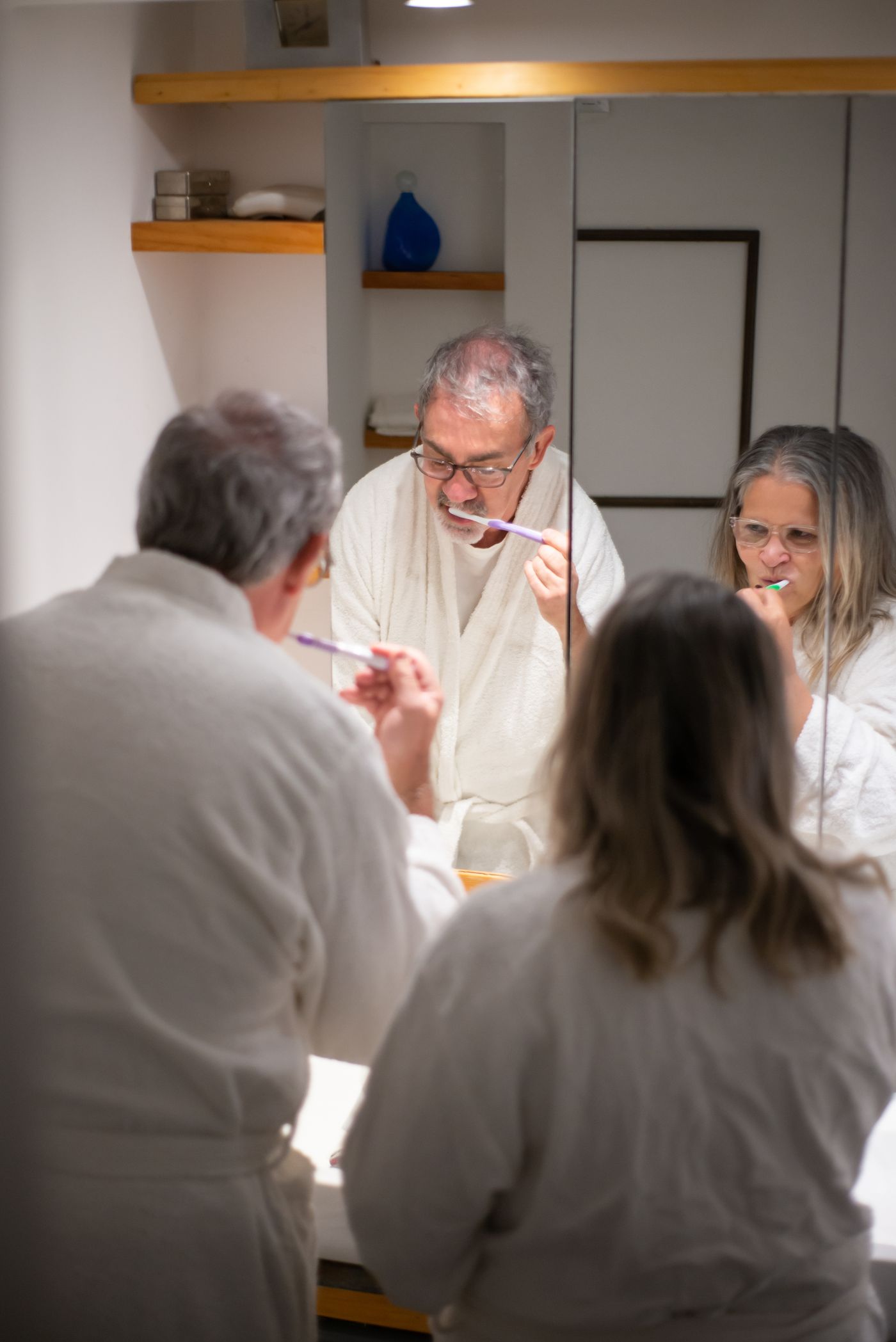 An older couple brushing their teeth together