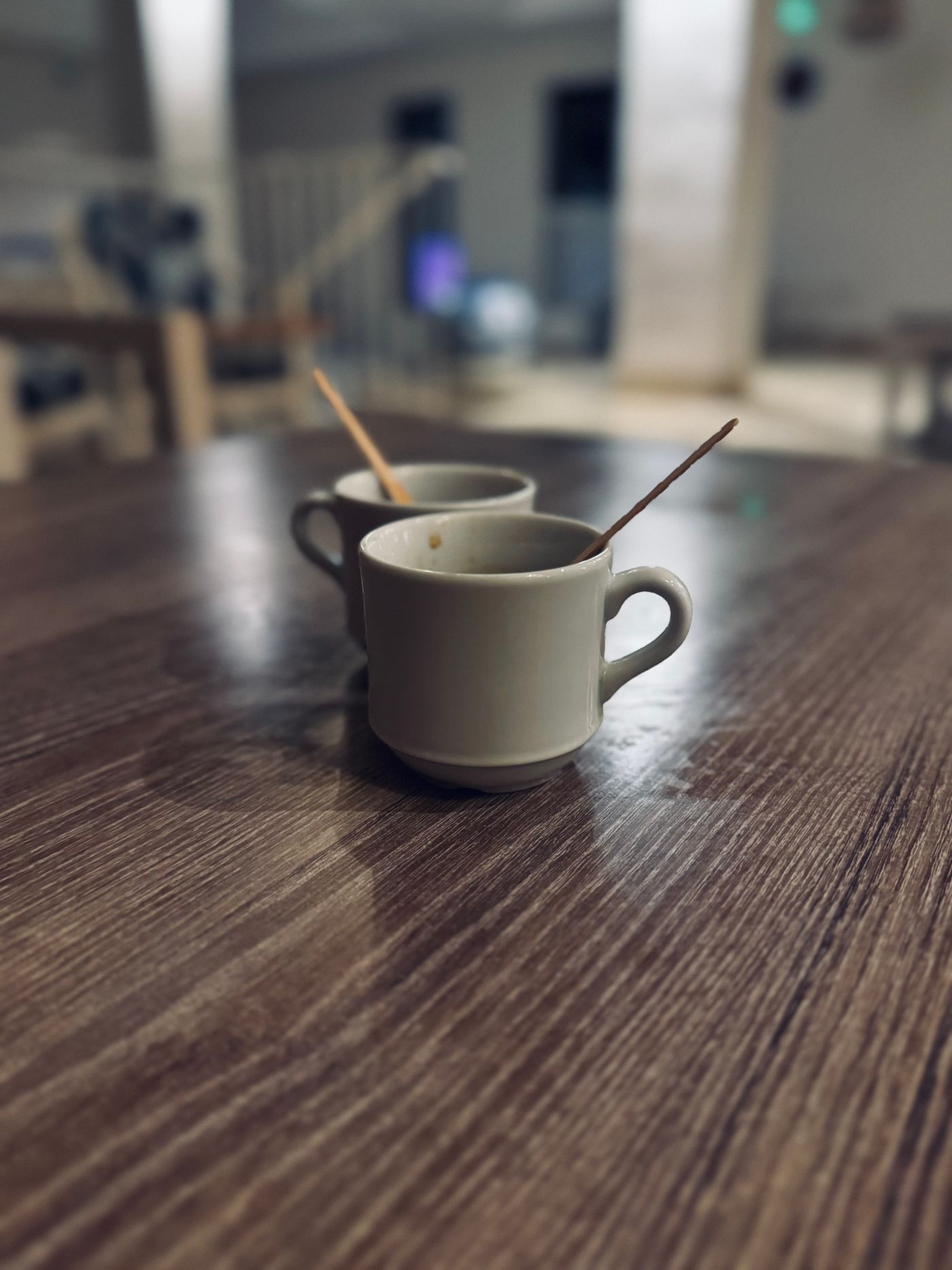 Two cups of coffee on a dark wooden table