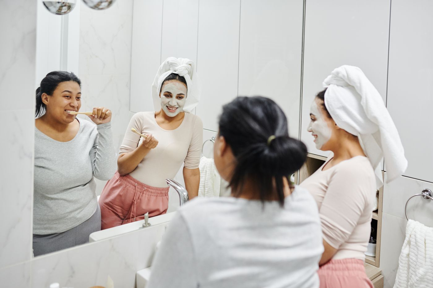 Friends going through a morning skincare and oral-care routine together
