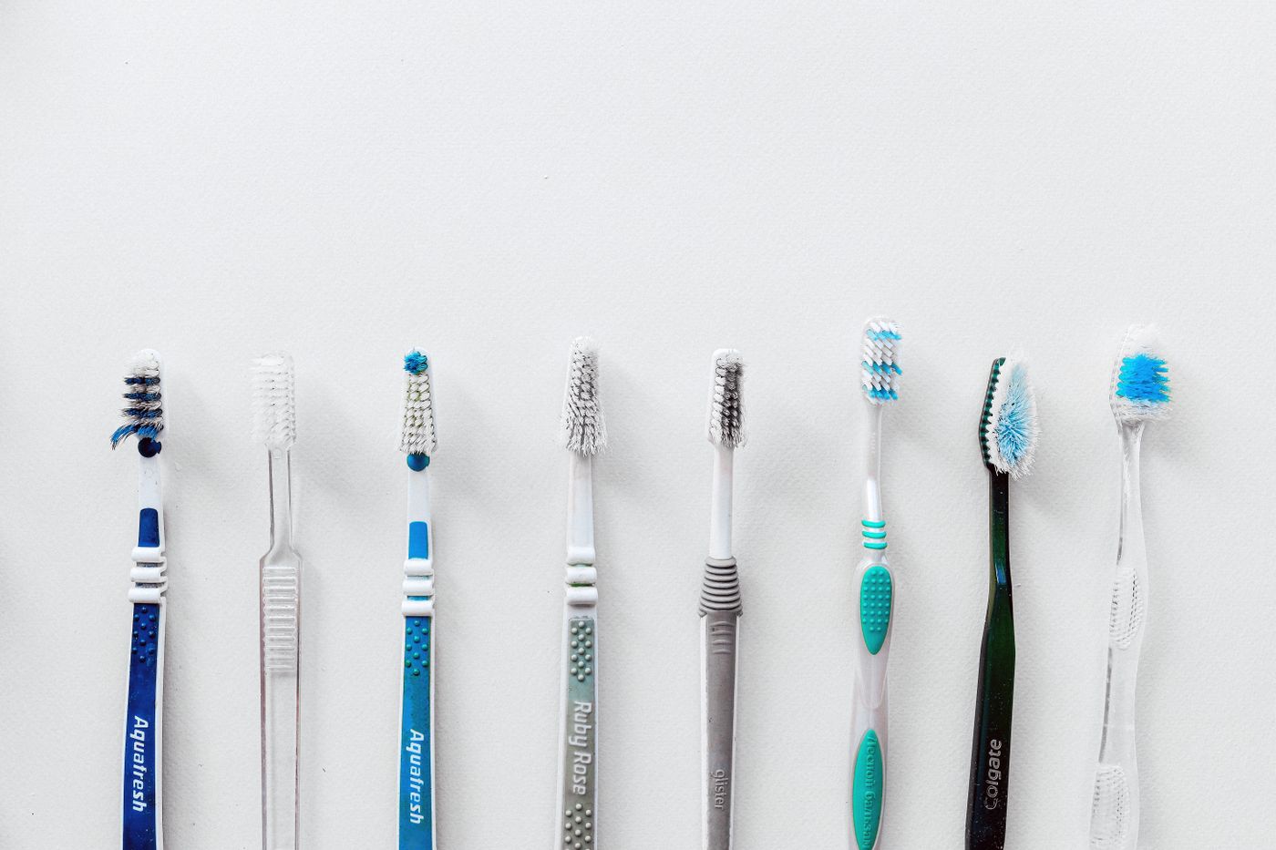 A row of different toothbrushes laid side by side