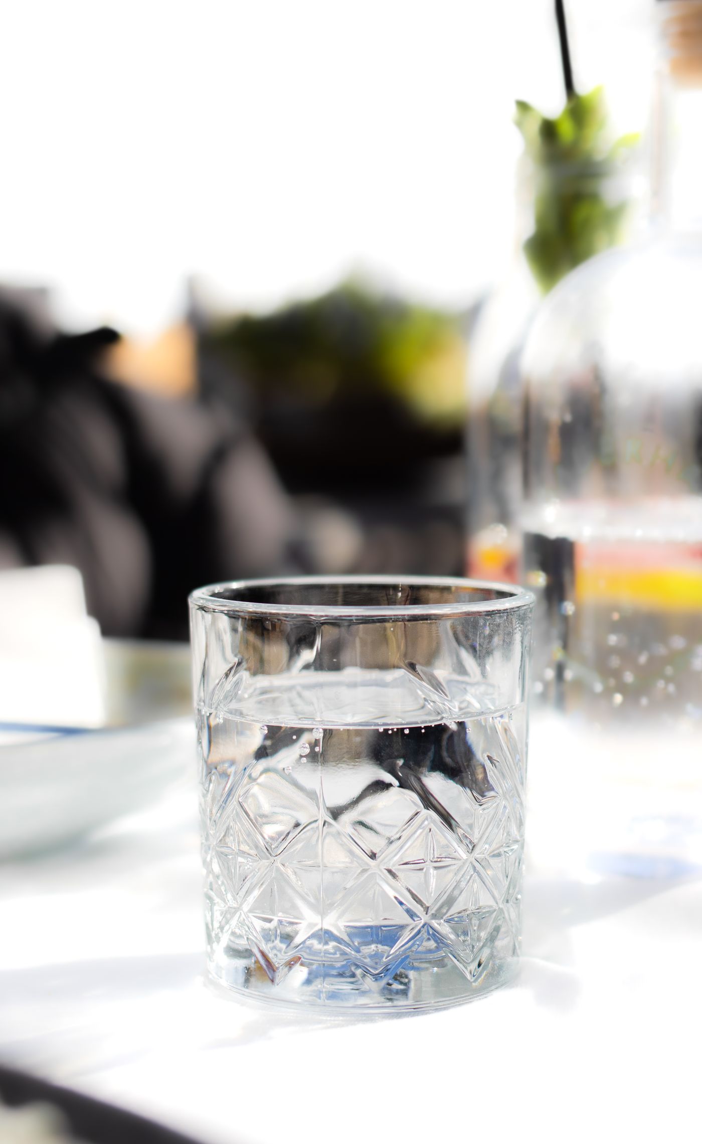 A glass of water on a sunlit table