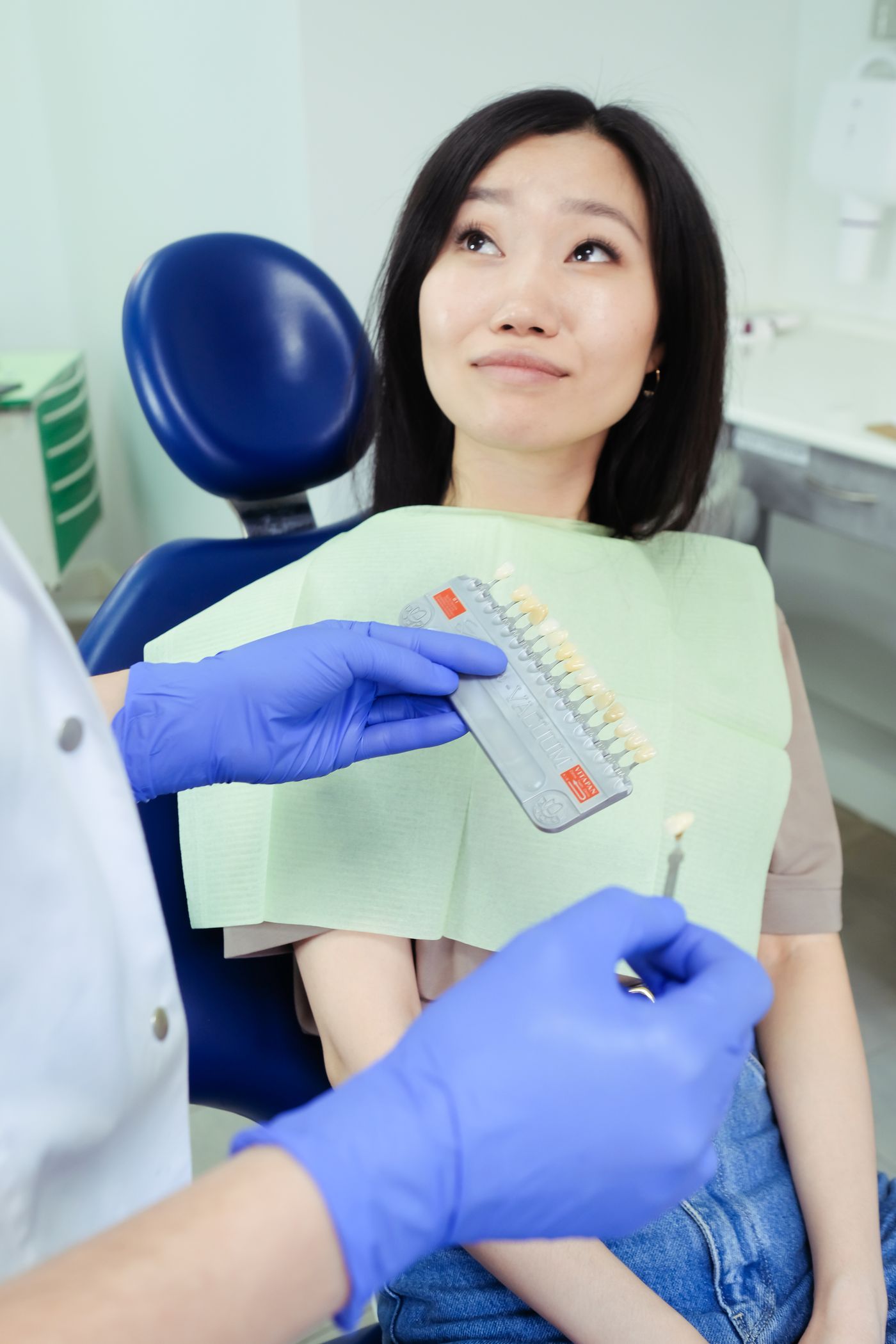 A dental professional matching a tooth shade during an appointment